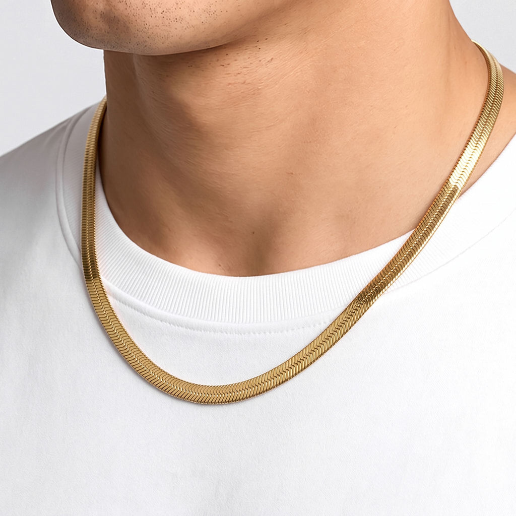 Köprücük kemiğinin altında sıvı gibi parlayan gold herringbone örgü, yakın plan