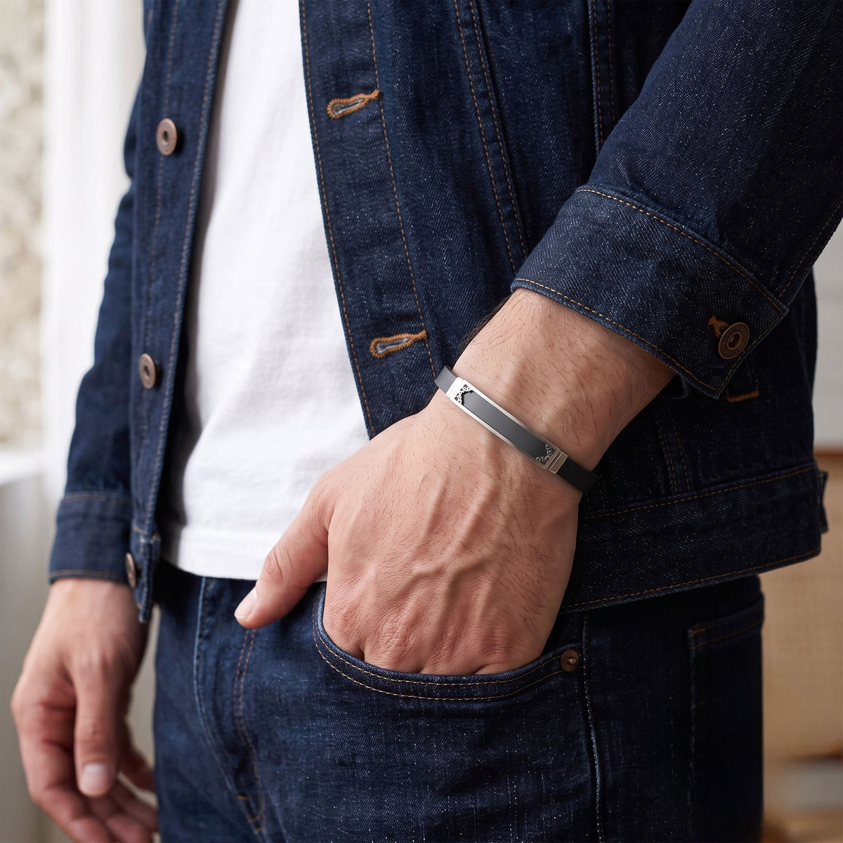 Denim ceket cebinde duran elin bileğinde siyah bantlı sade çelik plaka
