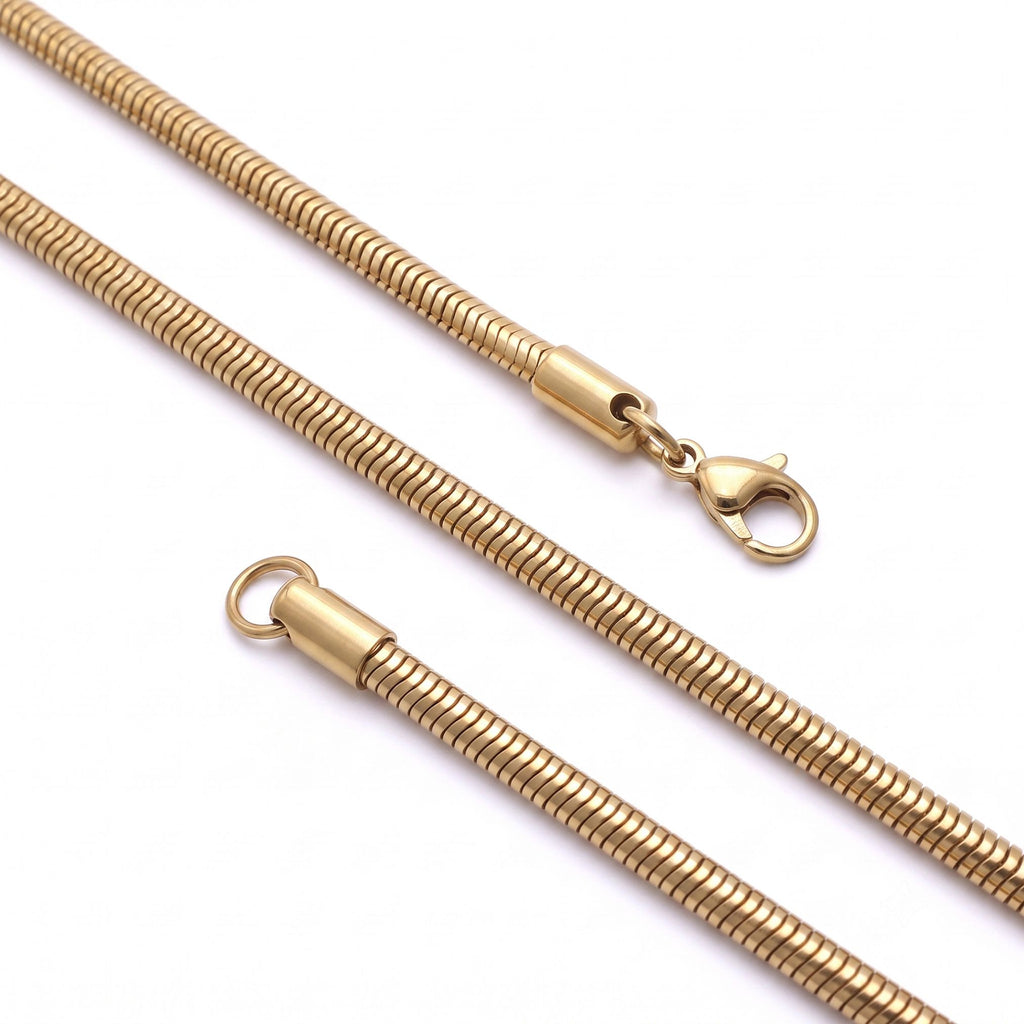 Çapraz yerleştirilmiş 5 mm altın tonlu oval spiral zincir ve kilidi, sade açık zeminde